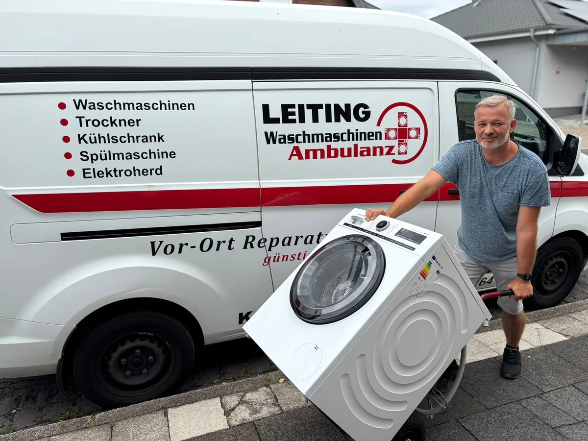 Techniker der Waschmaschinen-Ambulanz mit Waschmaschine am Servicefahrzeug